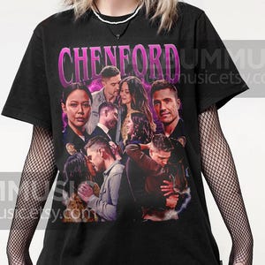May include: Black t-shirt with a graphic print of the cast of the TV show "Chenford". The graphic is in a retro style with pink and purple accents. The text "Chenford" is printed in large, bold letters.