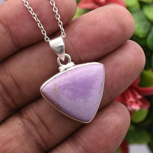 May include: A silver necklace with a triangular pendant. The pendant has a pale purple stone set in a silver bezel. The chain is a delicate silver link style. The pendant is centered in the image.