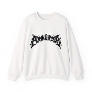 Op de afbeelding: Witte crewneck sweatshirt met het woord "PUNKSHTER" in een zwarte, gotische lettertype over de borst. De sweatshirt heeft lange mouwen en een casual ontwerp.