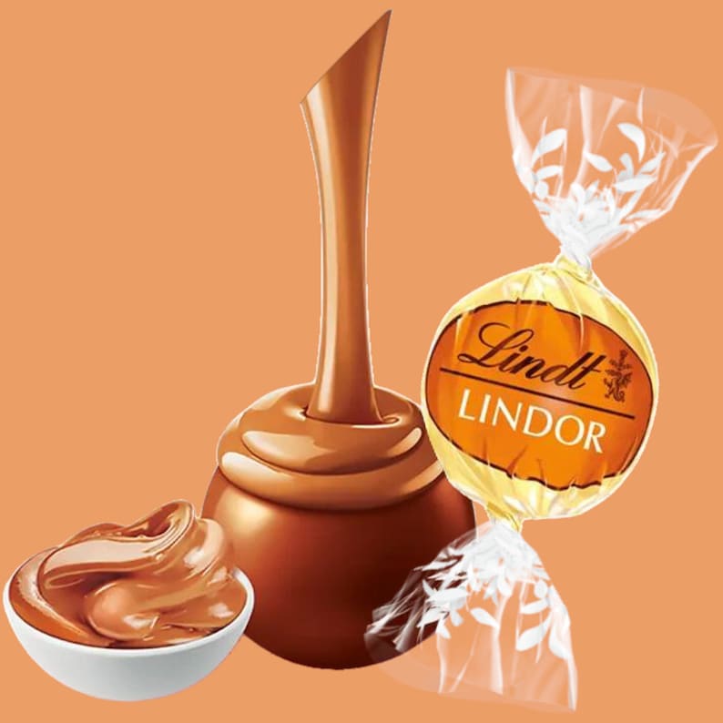 Op de afbeelding: Een Lindt Lindor chocoladetruffel met een romige, rijke karamelvulling. De chocolade wordt gegoten uit een tuit, waardoor de romige textuur wordt benadrukt. Het Lindt Lindor logo is zichtbaar op de verpakking.