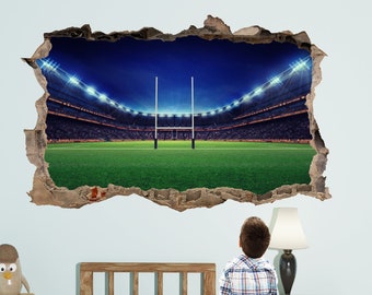 May include: A 3D wall decal depicting a rugby stadium with a green field, white goal posts, and a night sky with stadium lights. The decal is placed on a wall in a room with a bed and a lamp.