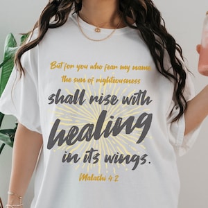 May include: White oversized t-shirt with a yellow and gray graphic print that reads "But for you who fear my name the sun of righteousness shall rise with healing in its wings. Malachi 4:2"