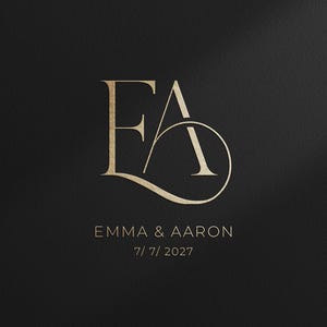 May include: Gold monogram logo with the letters "EA" intertwined, set against a dark background. Below the monogram, the names "Emma & Aaron" and the date "7/7/2027" are displayed in a complementary font.