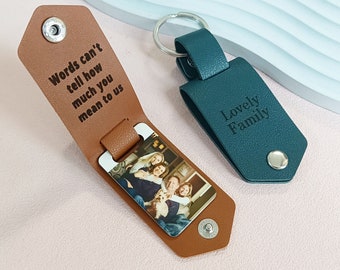 May include: A brown leather keychain with a photo insert and the text "Words can't tell how much you mean to us". The keychain also has a teal leather tag with the text "Lovely Family".