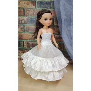 May include: White tulle and satin petticoat with two layers of ruffles. The petticoat is designed for a doll and is approximately 12 inches in diameter.