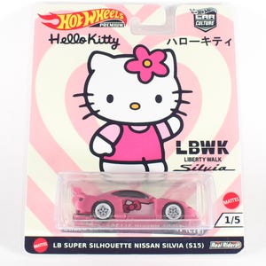 May include: A pink Hot Wheels Premium car with Hello Kitty branding. The car is a 1/5 scale Nissan Silvia with a Liberty Walk body kit. The packaging features a cartoon image of Hello Kitty and the text "LB Super Silhouette Nissan Silvia (S15)".