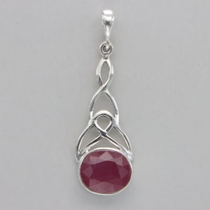 May include: A silver pendant with a Celtic knot design and a red ruby gemstone.