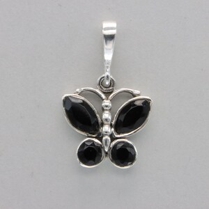 May include: Silver butterfly pendant with black gemstone accents.