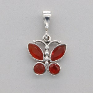 May include: Silver butterfly pendant with red gemstone accents.