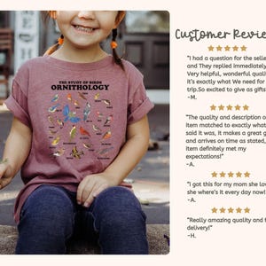 May include: A maroon t-shirt featuring a graphic of a circle of various bird illustrations. The text "THE STUDY OF BIRDS ORNITHOLOGY" is printed above the circle of birds.