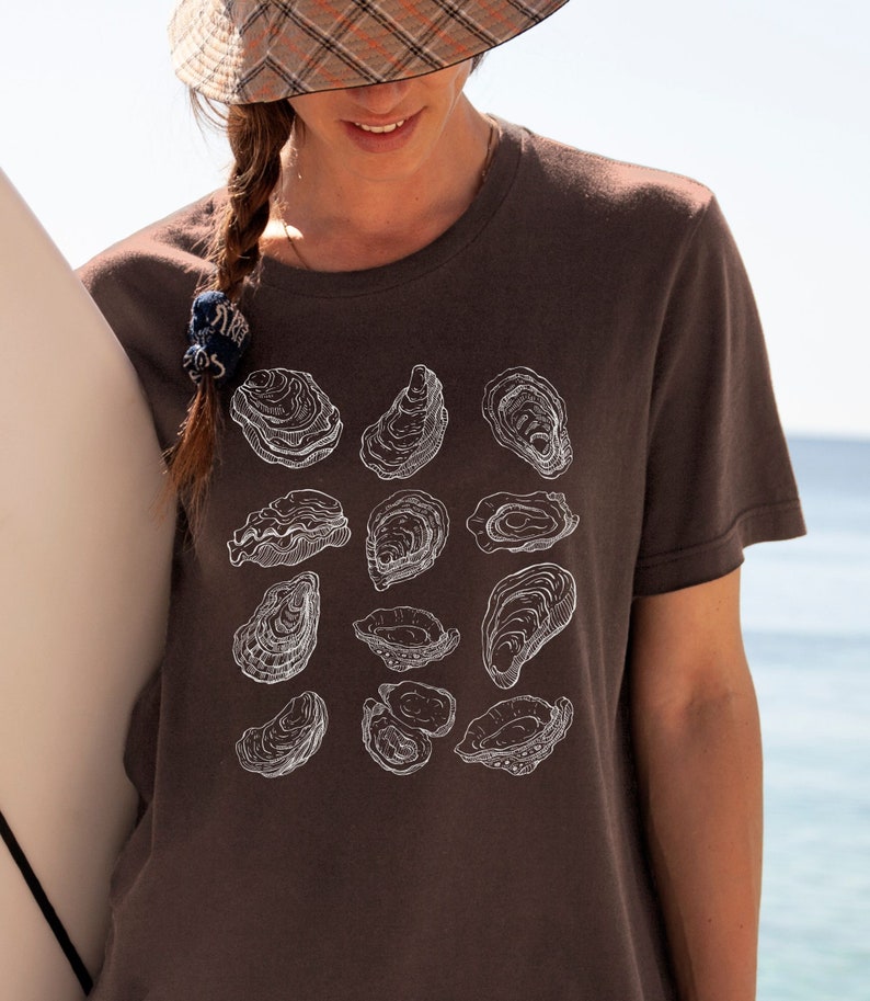 May include: A brown t-shirt with a white graphic print of various oyster shells.