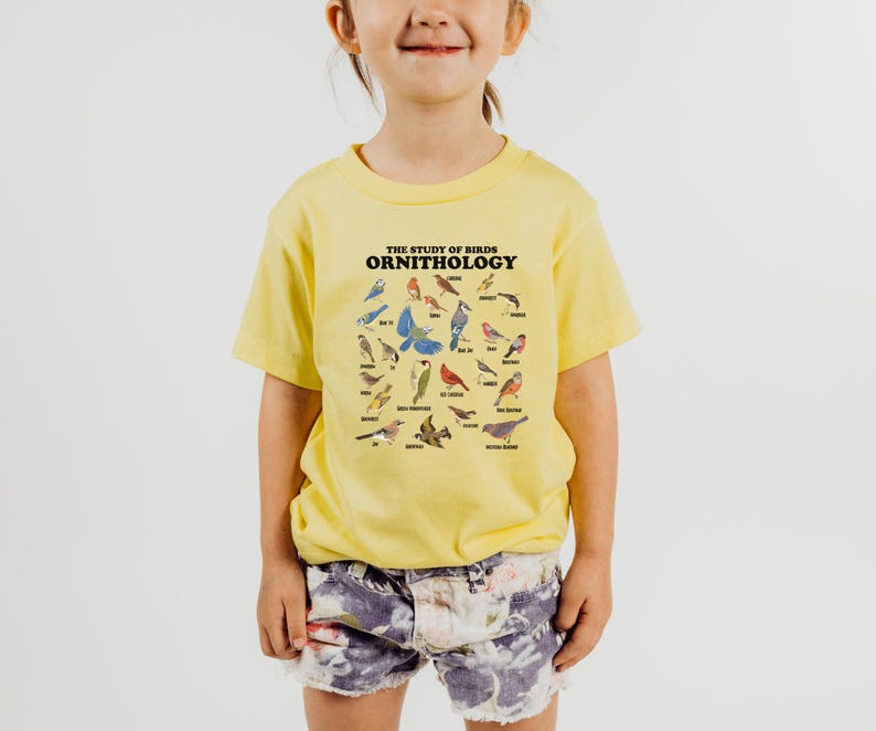 May include: A yellow t-shirt with a graphic of various birds and the text "THE STUDY OF BIRDS ORNITHOLOGY".