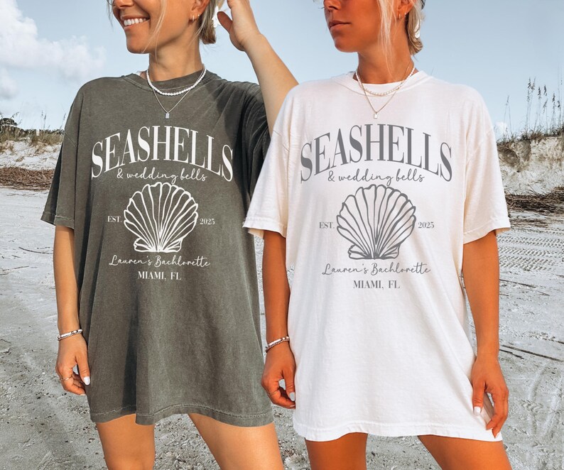 May include: Two women wearing oversized t-shirts with a seashell graphic and the text "Seashells & wedding bells" and "Lauren's Bachelorette Miami, FL".