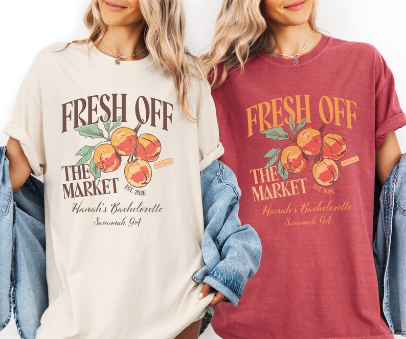 May include: Two t-shirts, one cream and one burgundy, feature the text "FRESH OFF THE MARKET" above a peach branch illustration. Below, the text reads "Hanali's Bachelorette Savannah, GA" and "EST. 2026".