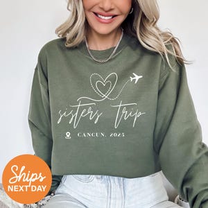 a woman wearing a sweatshirt that says sisters trip