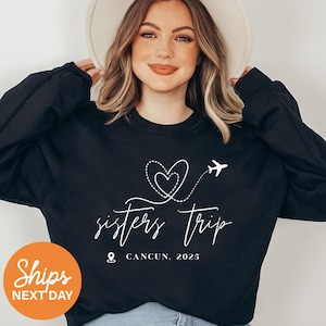 a woman wearing a black sweatshirt with a heart on it
