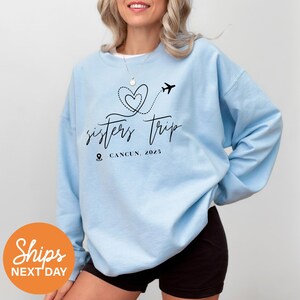 a woman wearing a blue sweatshirt with a heart on it