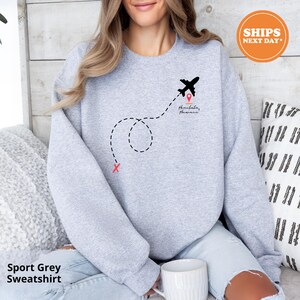 a woman sitting on a bed with a cup of coffee