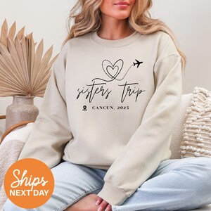 a woman sitting on a couch wearing a sweatshirt