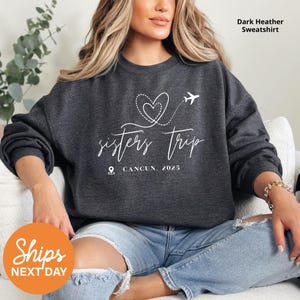 a woman sitting on a couch wearing a sweatshirt