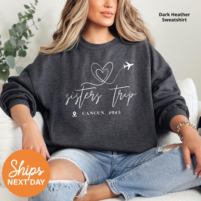 a woman sitting on a couch wearing a sweatshirt