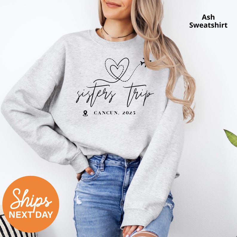 a woman wearing a sweatshirt that says sisters trip