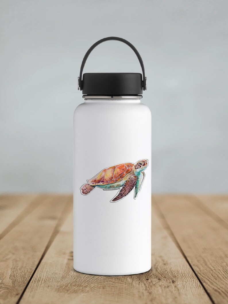 May include: A white stainless steel water bottle with a black lid and a black handle. A colorful watercolor sticker of a sea turtle is on the front of the bottle.