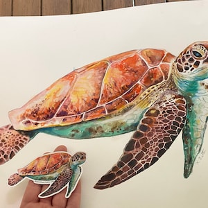 May include: Watercolor painting of a large sea turtle with a smaller sea turtle beside it. The larger turtle has a brown, orange, and green shell. The smaller turtle has a similar shell but is smaller in size. The painting is signed "K. Miller Art".