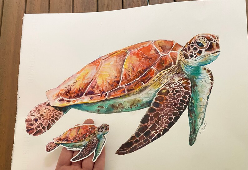 May include: Watercolor painting of a large sea turtle with a smaller sea turtle beside it. The larger turtle has a brown, orange, and green shell. The smaller turtle has a similar shell but is smaller in size. The painting is signed "K. Miller Art".