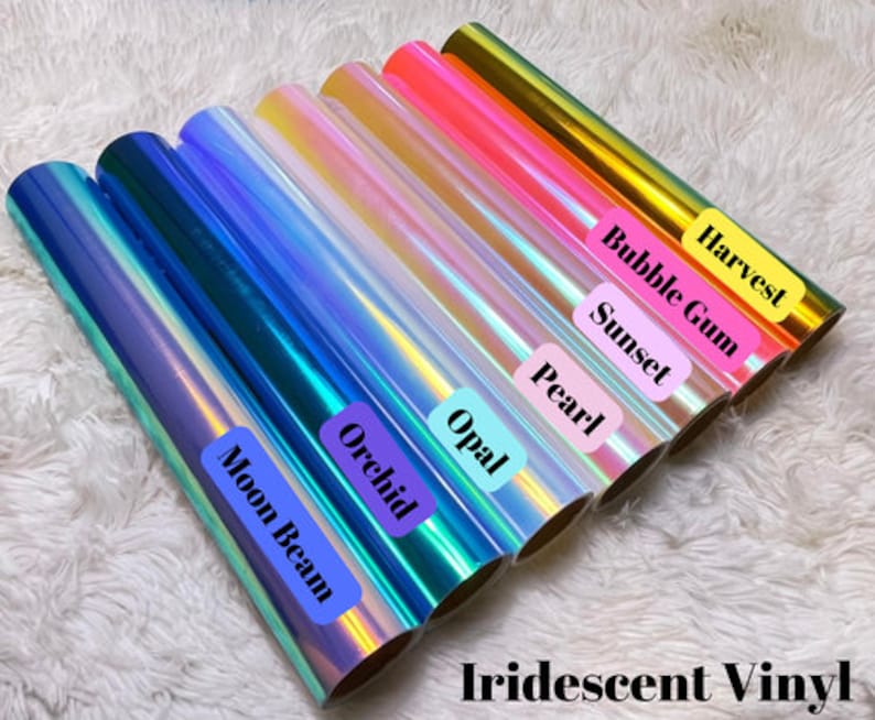 May include: Rolls of iridescent vinyl in various colors, including blue, purple, pink, and gold. Each roll is labeled with a color name, such as "Moon Beam" and "Harvest". The text "Iridescent Vinyl" is at the bottom.