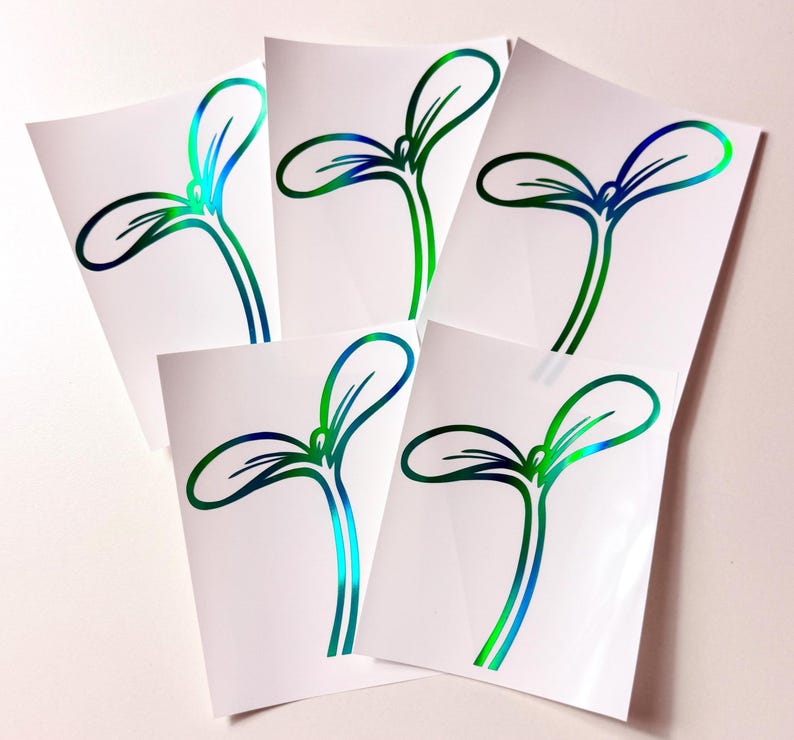 May include: Five white stickers featuring a stylized sprout design with green and blue iridescent outlines. The stickers are arranged in a fan shape, showcasing the design's details.