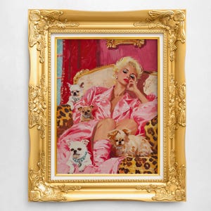 May include: A framed painting of a woman in a pink dressing gown relaxing on a sofa with four small white dogs. The sofa is covered in a leopard print fabric. The woman is wearing a pink dressing gown and has blonde hair. The painting is set in a gold frame.
