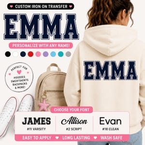 May include: Cream-colored hoodie with the name "EMMA" in navy blue varsity lettering on the back. The image also shows options for custom iron-on transfers, including various fonts and colors, perfect for personalizing apparel and accessories.