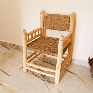 Pode incluir: Uma cadeira de madeira com assento e encosto de palha tran&ccedil;ada. A cadeira tem um design simples com um assento e encosto retangulares, e quatro pernas.