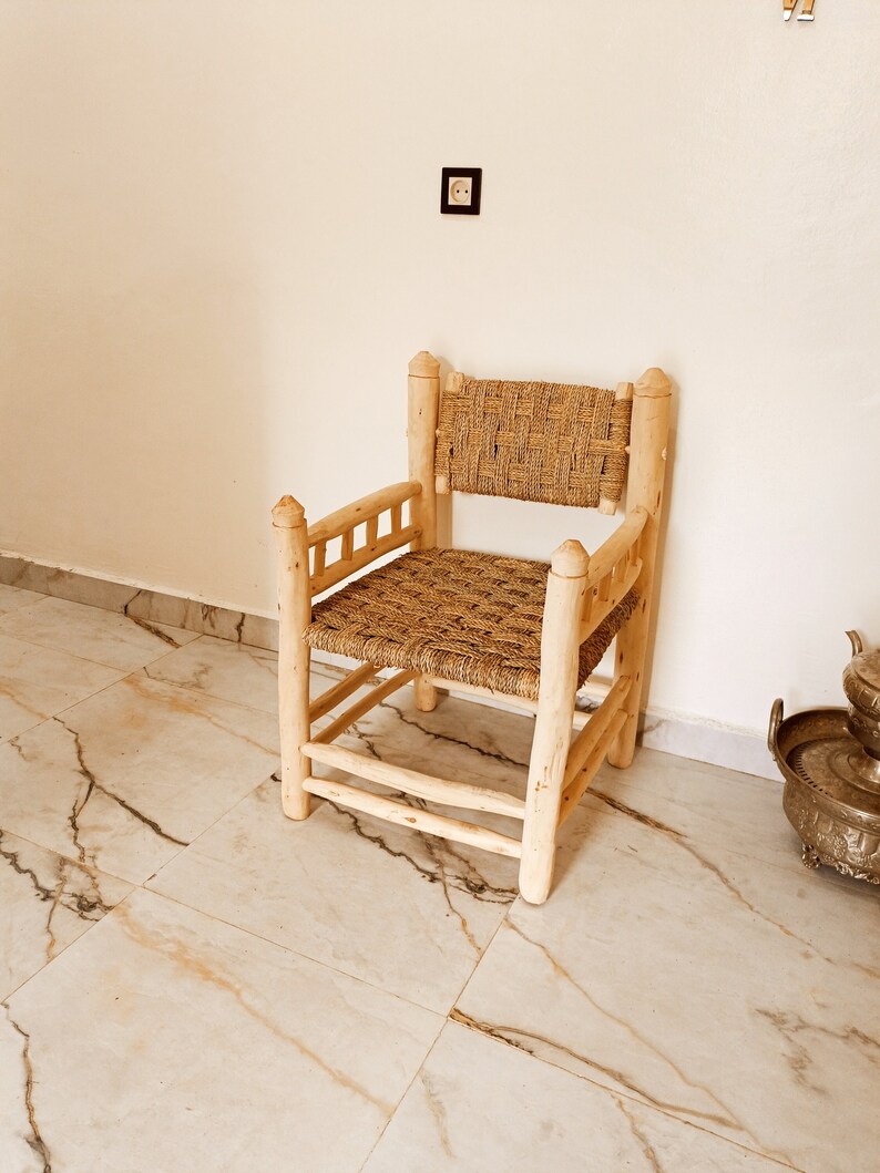 Pode incluir: Uma cadeira de madeira com assento e encosto de palha tran&ccedil;ada. A cadeira tem um design simples com um assento e encosto retangulares, e quatro pernas.