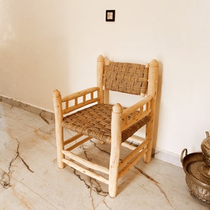 Pode incluir: Uma cadeira de madeira com assento e encosto de palha tran&ccedil;ada. A cadeira tem um design simples com um assento e encosto retangulares, e quatro pernas.