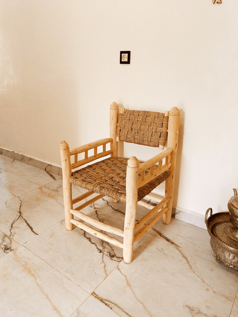 Pode incluir: Uma cadeira de madeira com assento e encosto de palha tran&ccedil;ada. A cadeira tem um design simples com um assento e encosto retangulares, e quatro pernas.