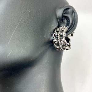 Puede incluir: Pendientes de aro de plata con un diseño detallado e intrincado. Los pendientes están hechos de múltiples cadenas enlazadas con pequeñas cuentas.