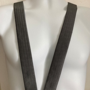 May include: A pair of black and white herringbone suspenders.