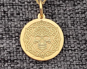Könnte beinhalten: Goldene Halskette mit einem runden Anhänger, der einen Schädel zeigt, der von einem keltischen Knotenmuster umgeben ist.