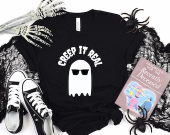 May include: Black t-shirt with a white ghost wearing sunglasses and the text "Creep It Real".