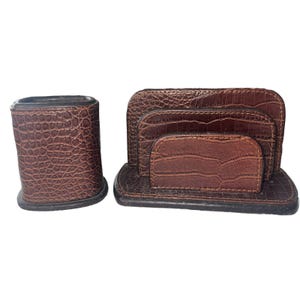 May include: A brown leather desk organizer with a pen holder and a letter holder. The organizer has a crocodile pattern.