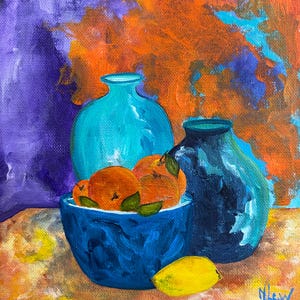 May include: An original still life painting featuring a blue bowl filled with oranges, a yellow lemon, and two blue vases. The background has a vibrant mix of orange, purple, and blue hues. The artwork is signed in the bottom right corner.