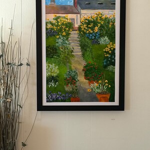 May include: Framed painting of a garden path leading to a house. The artwork features a vibrant display of yellow sunflowers, red and purple flowers in pots, and lush green foliage. The sky is a bright blue.
