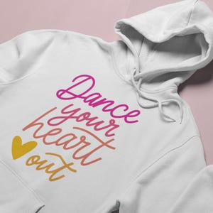 May include: White hoodie with a pink, orange, and yellow graphic that says "Dance your heart out" with a yellow heart.