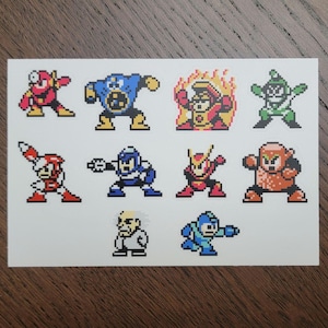 Könnte beinhalten: Eine weiße Karte mit Pixelkunst-Charakteren aus einem Videospiel. Die Charaktere sind in verschiedenen Farben, darunter Rot, Blau, Grün und Orange. Die Charaktere befinden sich in verschiedenen Aktionsposen.