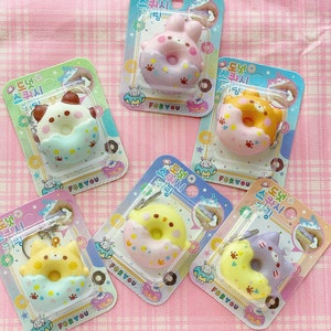 May include: Six colorful donut-shaped squishies with animal faces. Each squishy has a different animal face and is decorated with sprinkles and paw prints. The squishies are packaged in clear plastic bags with Korean text that reads "Donut Squishy".