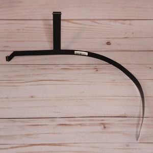 May include: Black flexible ribbon cable with a connector on one end and a bend in the middle. The cable is on a light wood surface.