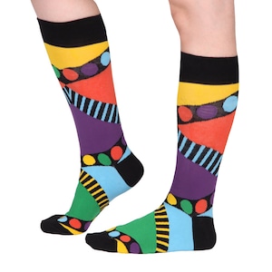 Könnte beinhalten: Ein Paar bunte Kniestrümpfe mit einem geometrischen Muster in den Farben Gelb, Orange, Rot, Lila, Blau, Grün und Schwarz.