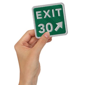 May include: A green and white exit sign with the text "EXIT 30" and a white arrow pointing to the right.
